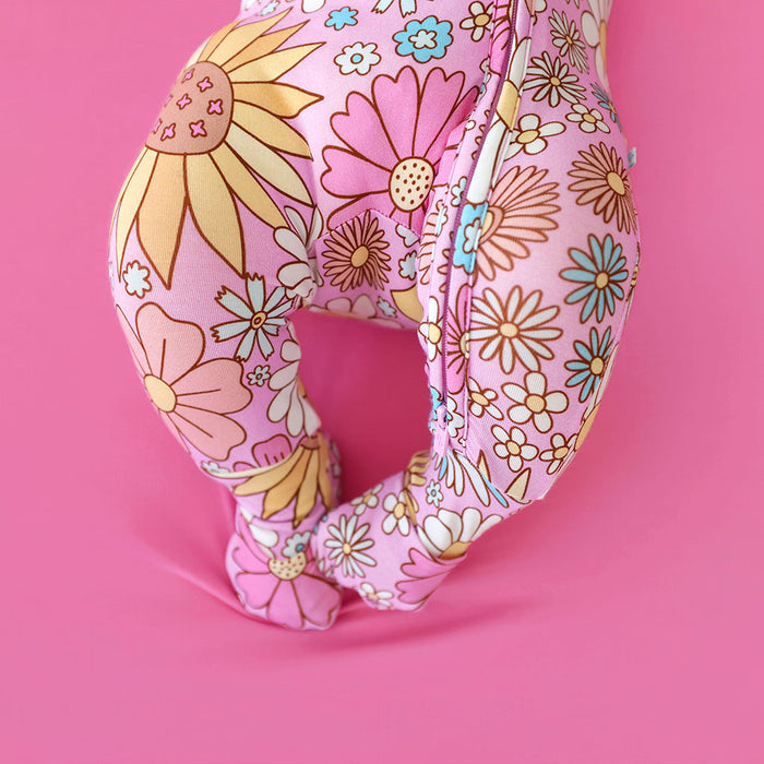 Baby in a Floral-patterned one piece on a pink background