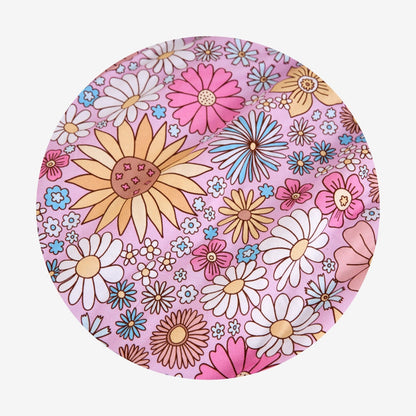 Round pink swatch with colorful floral pattern on a white background