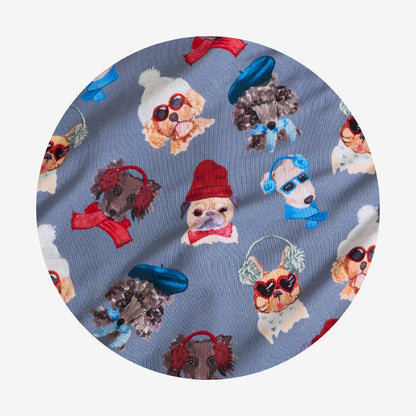 Fabric with a pattern of dogs wearing sunglasses, hats, and bows on a blue background.
