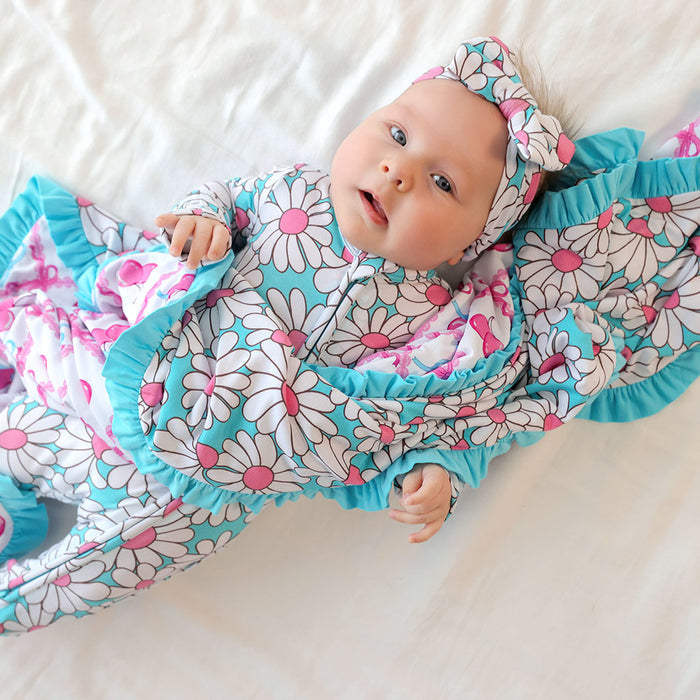 Baby in a floral outfit with ruffles on a white background