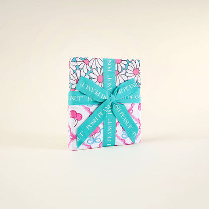 wrapped blanket with floral pattern and turquoise ribbon on a beige background