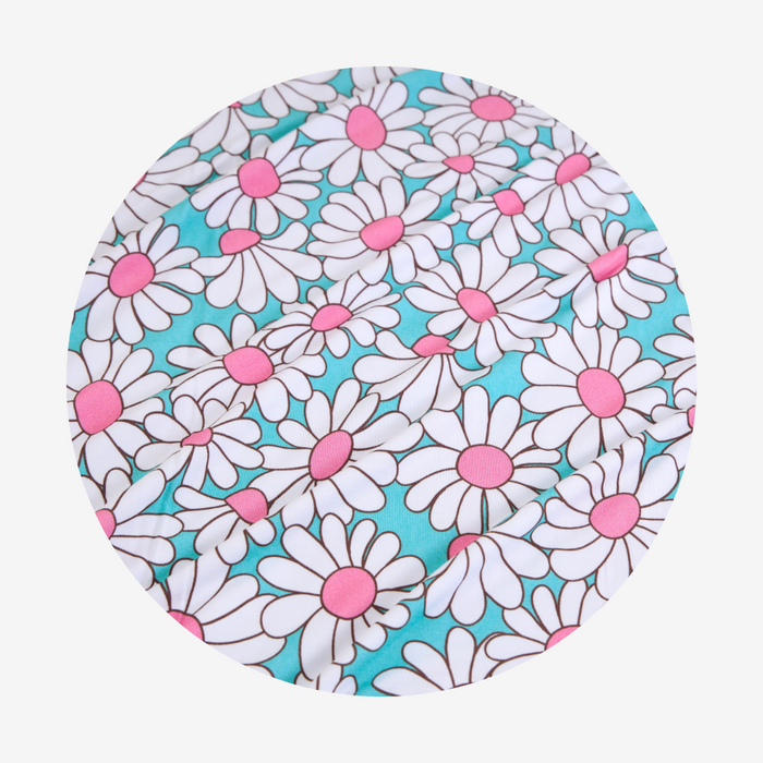 Round fabric swatch with white daisy pattern on a blue background