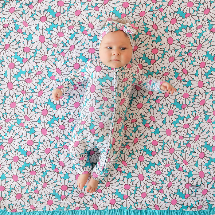 Baby lying on a floral patterned blanket