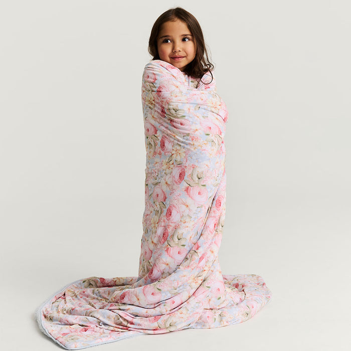 Child wrapped in floral patterned blanket