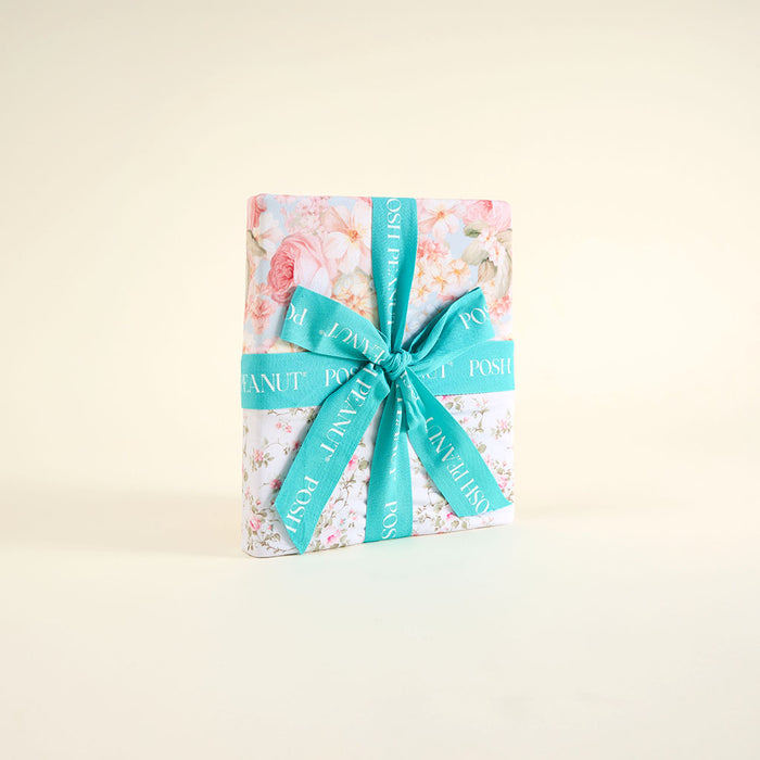Floral patoo folded with a turquoise ribbon on a light beige background