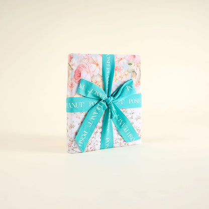 Floral patoo folded with a turquoise ribbon on a light beige background