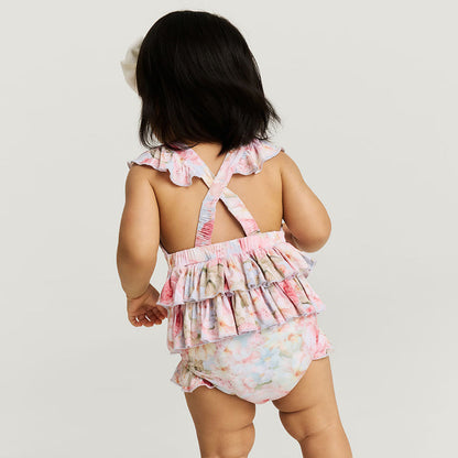 Back image of baby wearinga floral romper with criss cross back detail