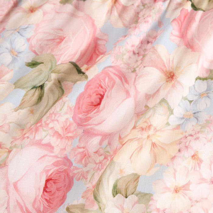 Close-up of pink and white flowers with green leaves on a light blue background