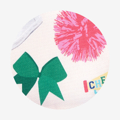 Close-up of fabric with a green bow and pink pom-pom on a white background.