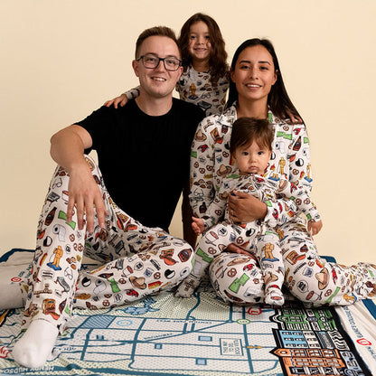 Family of four wearing matching pajamas with a pattern on a beige background