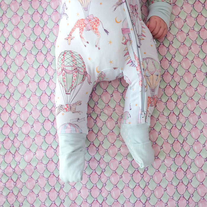 close up of footie detail of baby wearing a convertible one piece with circus animal and hot air balloon print.