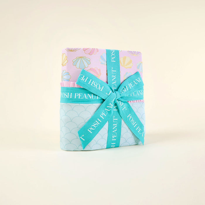 wrapped blanket with a blue ribbon on a light beige background