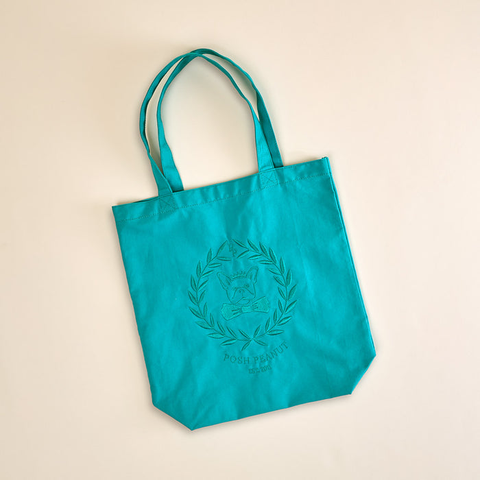 Turquoise tote bag with a logo on a beige background
