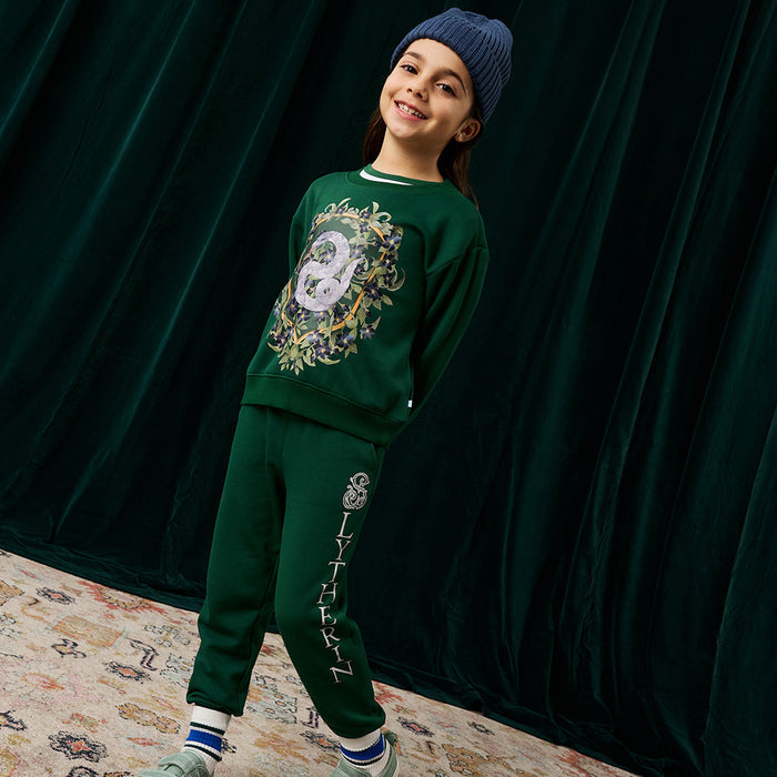 Child wearing green Harry Potter Slytherin sweatshirt and jogger set.