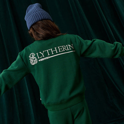 Child wearing green Harry Potter Slytherin sweatshirt.