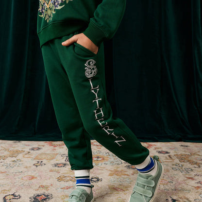 Child wearing green Harry Potter Slytherin jogger pants with hand in side pocket.