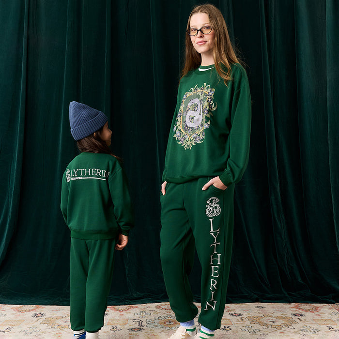 Adult and child wearing green Harry Potter Slytherin sweatshirt and jogger sets.