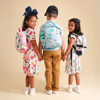 Three children holding hands, each wearing a colorful backpack on a beige background