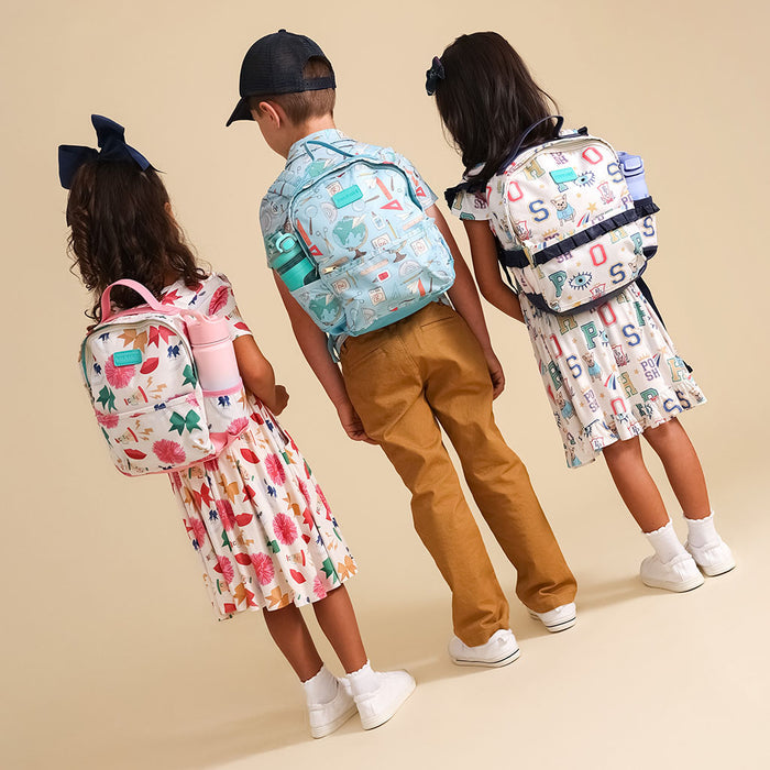 Three children wearing colorful backpacks on a beige background