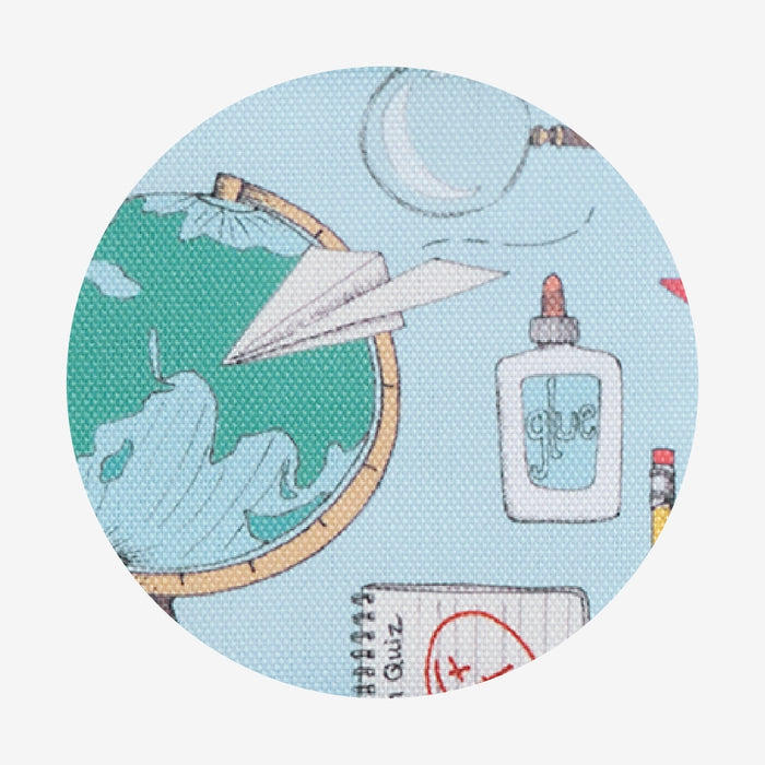 Fabric swatch with paper airplane, globe, and bottle design on a light blue background