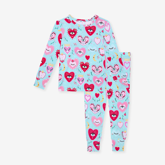 Children's pajama set with heart and eye pattern on a light blue background