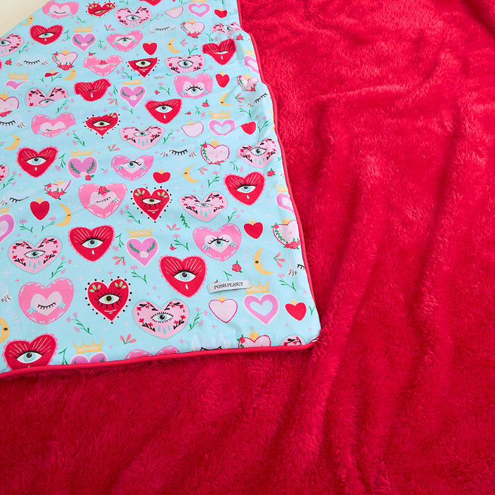 Blue and red blanket with a colorful heart pattern on a blue background