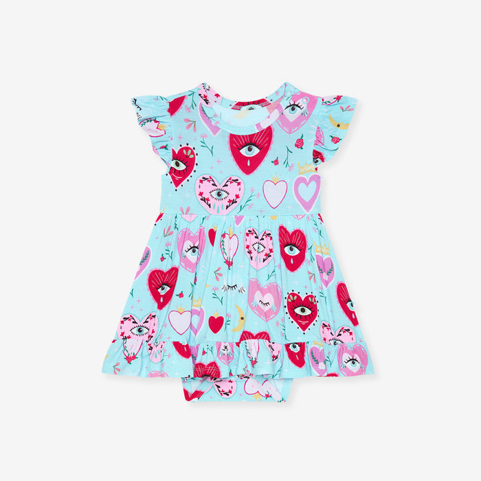Children's dress with heart and face pattern on a light blue background