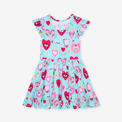 Children's dress with heart and eyes pattern on a light blue background