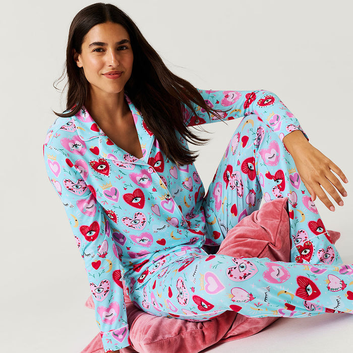 Woman wearing a colorful pajama set with heart patterns on a light background