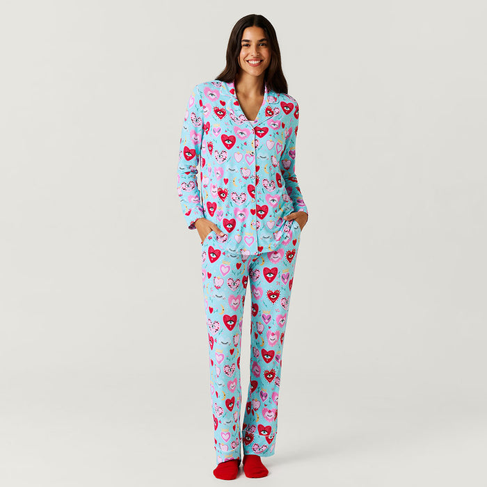 Woman wearing a heart-patterned pajama set on a plain background