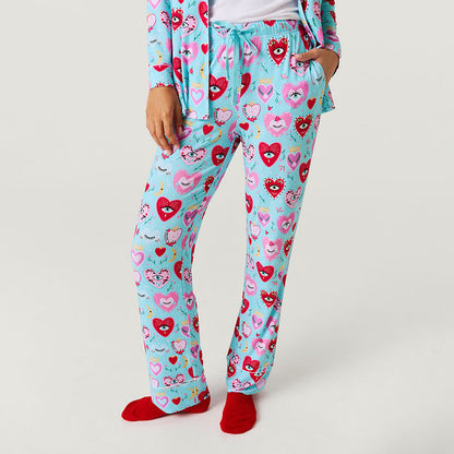 Person wearing a blue pajama set with heart patterns on a white background