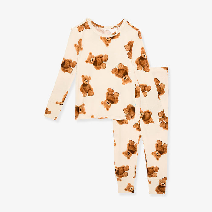 Children's pajama set with teddy bear pattern on a beige background