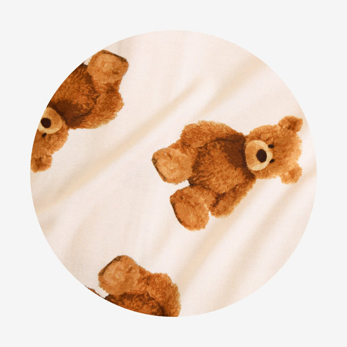 Round pillow with teddy bear pattern on a beige background