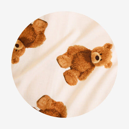 Round pillow with teddy bear pattern on a beige background